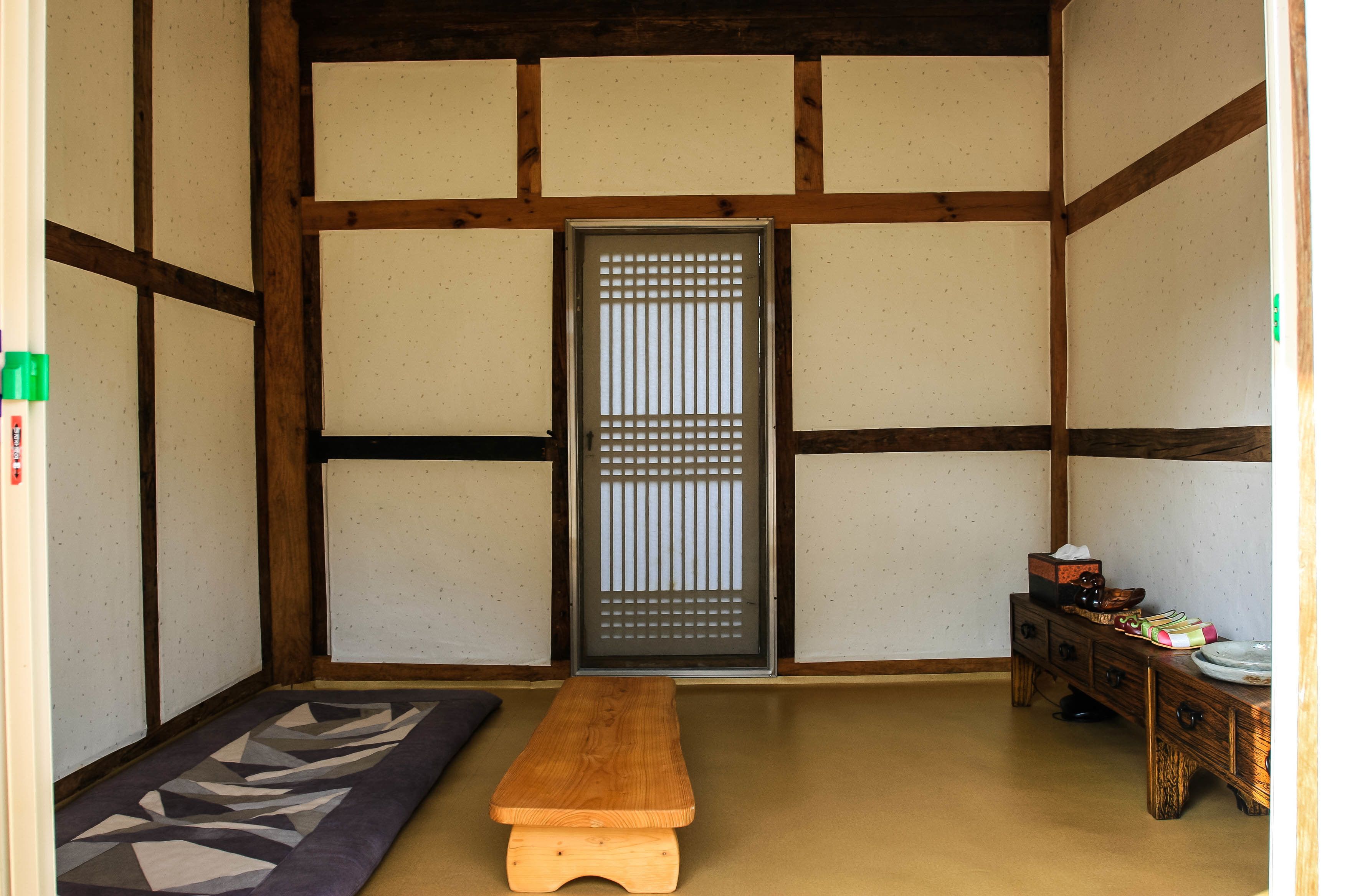 Ein traditioneller japanischer Raum mit Tatami-Boden, einer Shoji-Schiebetür und einer hölzernen Sitzbank.