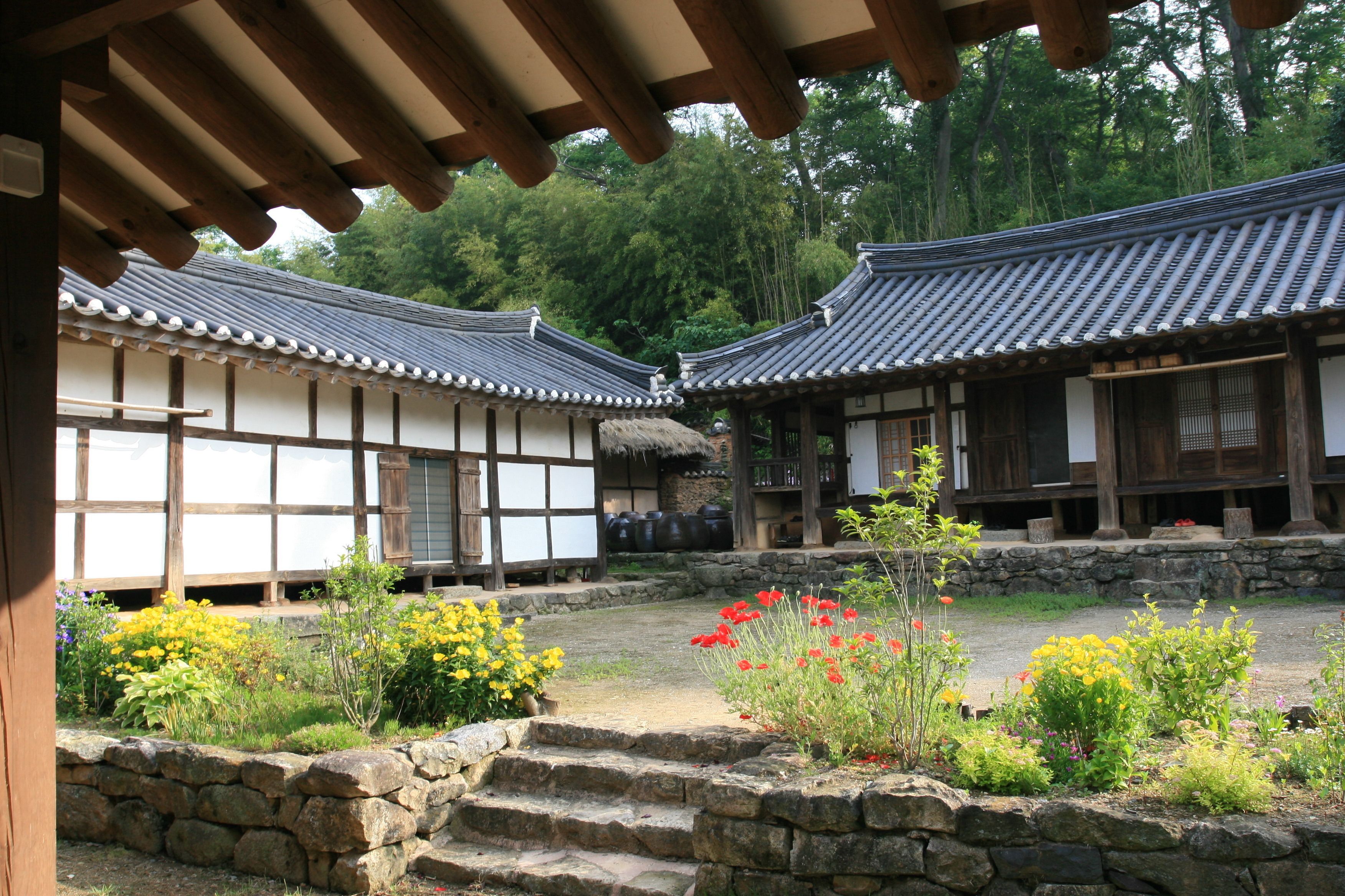 A traditional Japanese courtyard with wooden buildings and stone steps.