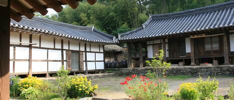 A traditional Japanese courtyard with wooden buildings and stone steps.