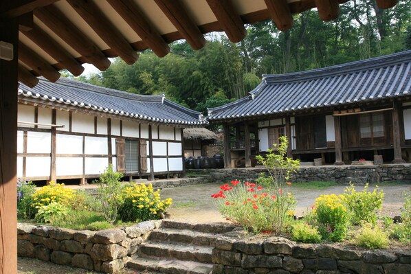 A traditional Japanese courtyard with wooden buildings and stone steps.