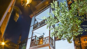 A two-story building with a balcony and a stone pathway leading to the entrance. - Akcasu Konuk Evi (Safranbolu)