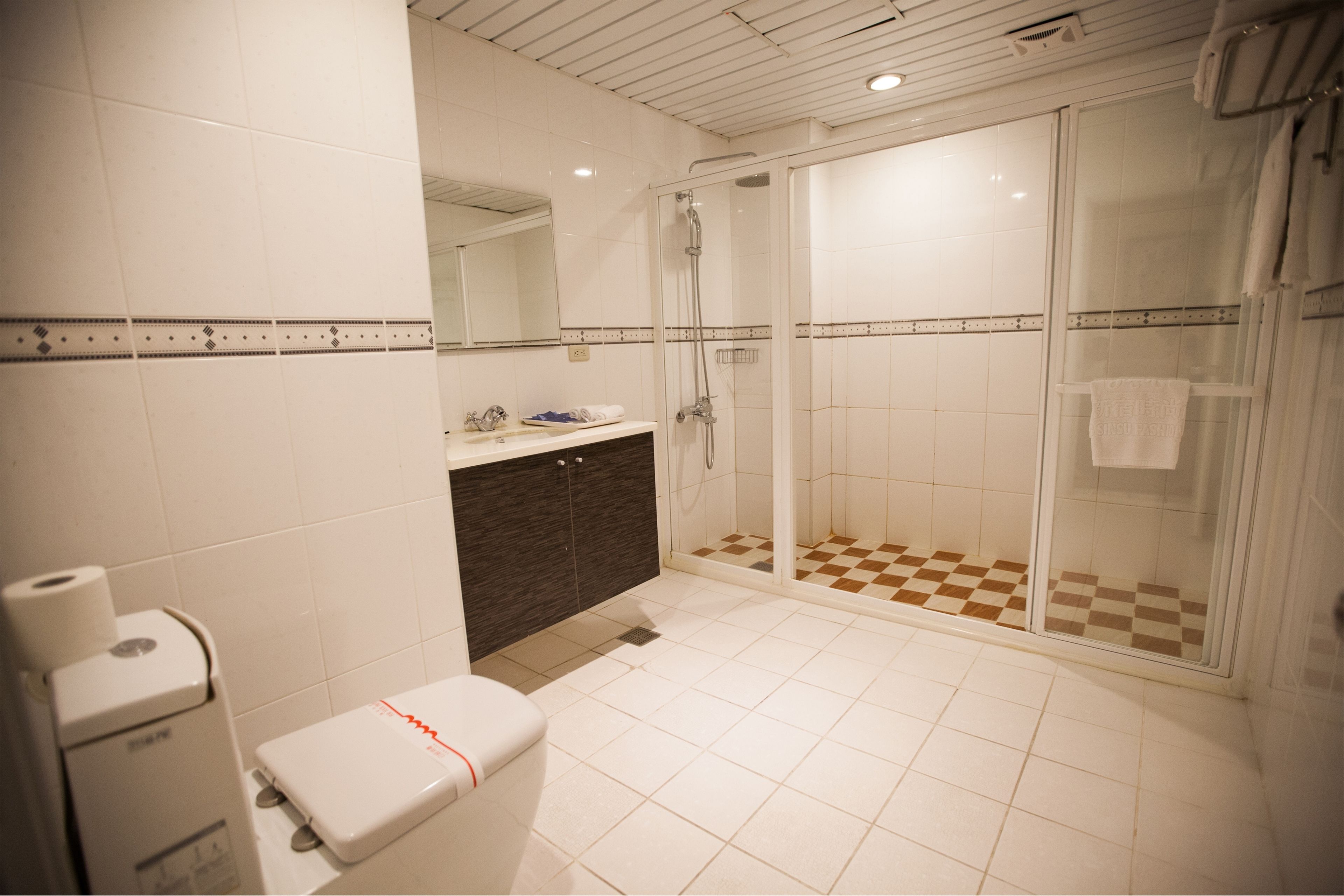 deluxe family room | bathroom | shower, hair dryer, slippers, towels