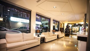 Un hall d’hôtel avec un grand sapin de Noël, des canapés et une enseigne indiquant « YES HOTEL ».
