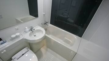 A modern bathroom with a sink, toilet, and bathtub.