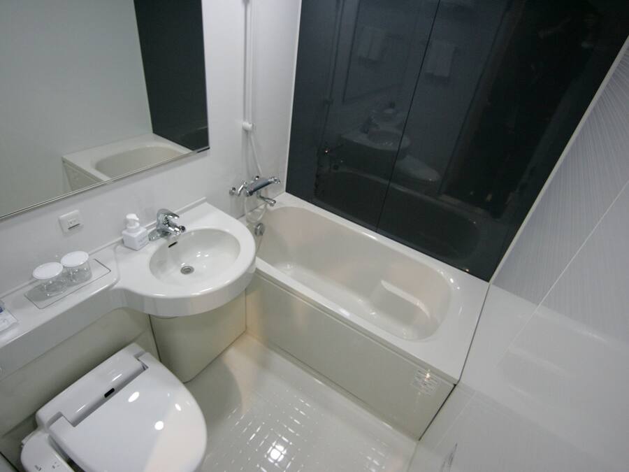 A modern bathroom with a sink, toilet, and bathtub.