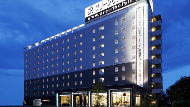 Un moderno edificio de hotel con un letrero llamativo que muestra el nombre y la página web.