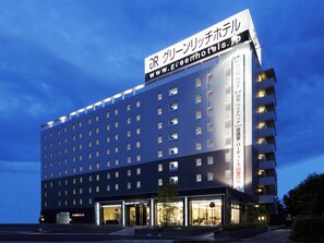 Un moderno edificio de hotel con un letrero llamativo que muestra el nombre y la página web.