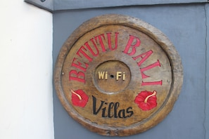 A wooden sign with the text "BETUTU BALI" and "Villas" indicating a location or establishment.