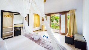 Een slaapkamer met een hemelbed, een kledingkast, een klein tafeltje met een decoratief object en uitzicht op de omgeving.