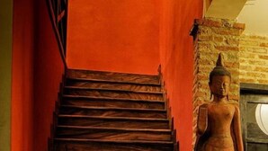 A wooden staircase with a Buddha statue at the top. - Villa Silk Road Hotel (Phnom Penh)
