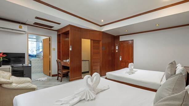 A hotel room with two beds, a TV, a desk, and a bathroom. - Break Point Patong Hotel (Patong)