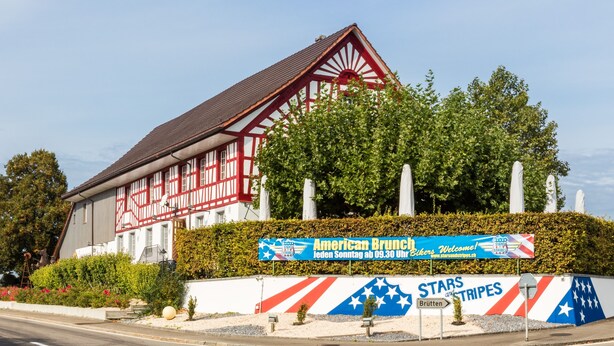 A traditional half-timbered building with a sign for 'American Brunch' and 'Stars and Stripes' restaurant. - Stars and Stripes - Motel Steighof (Brutten)