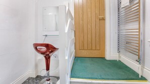 A bathroom with a white sink, a wooden door, and a towel rack. - St Mary's Guest House  (York)