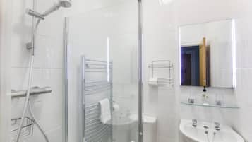 Chuveiro, secador de cabelo, toalhas de banho, papel higiênico