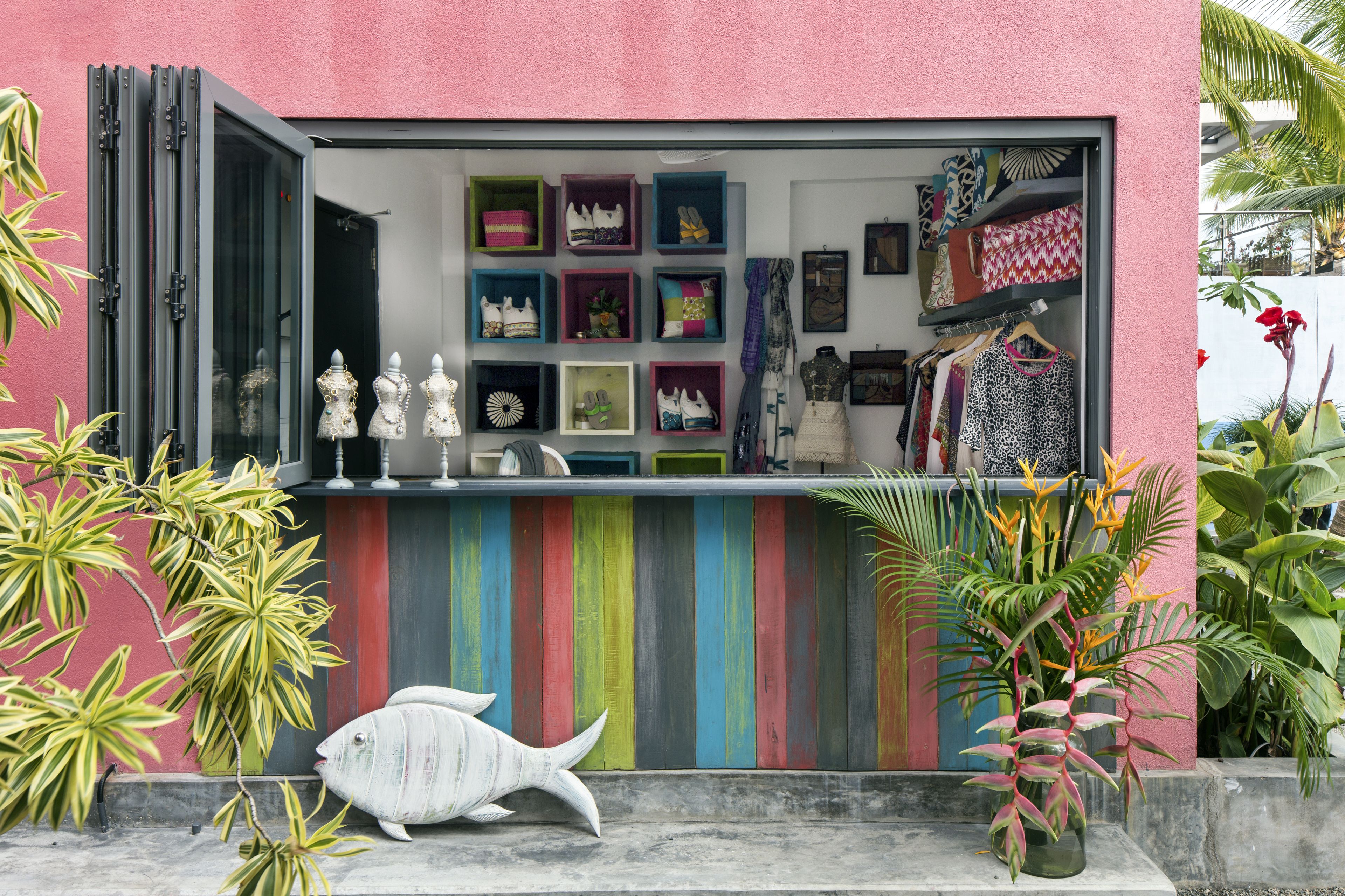 A colorful storefront with various items on display, including shoes and decorative objects.