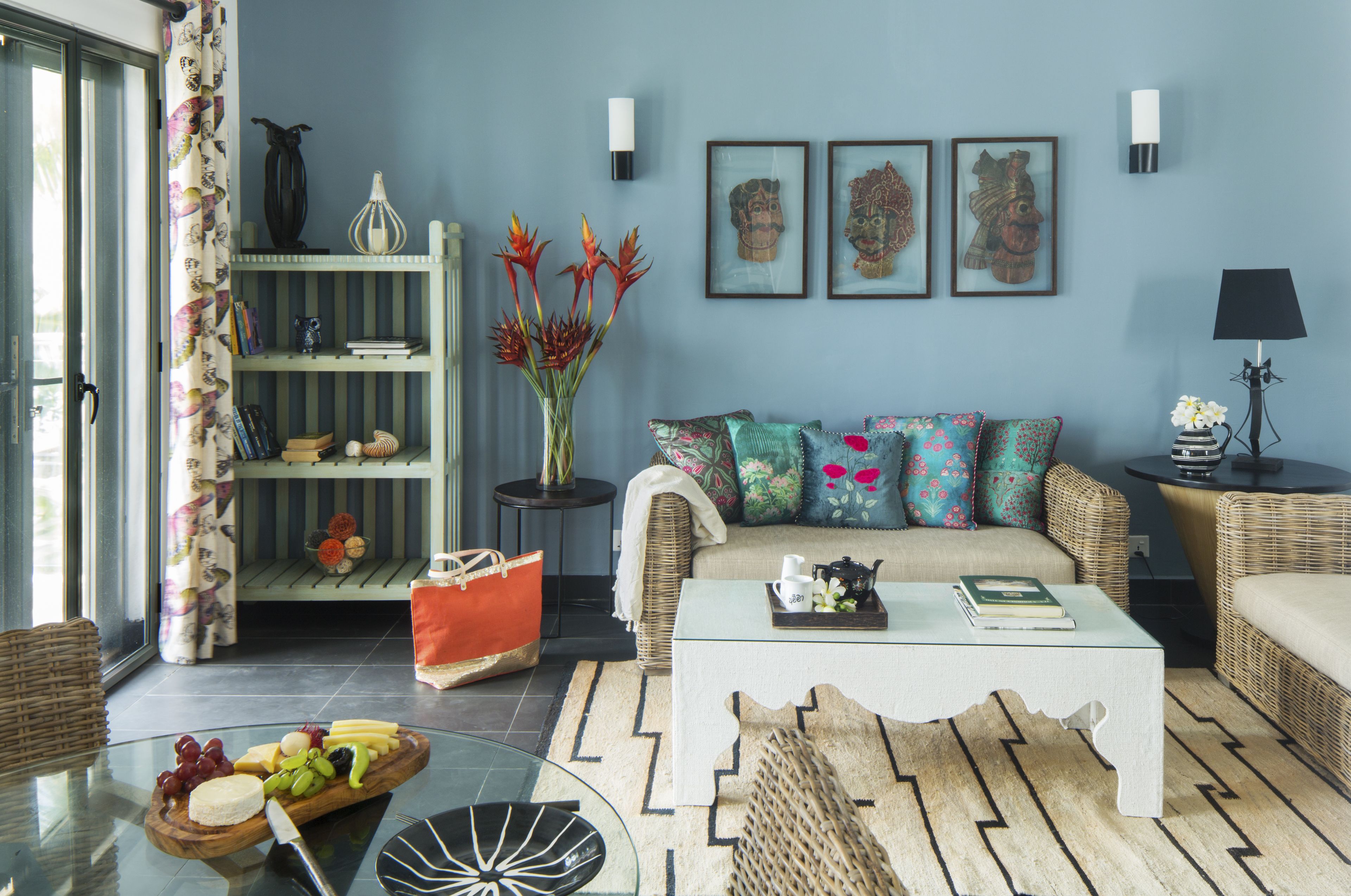 A living room with a sofa, coffee table, and a glass table with a fruit platter.