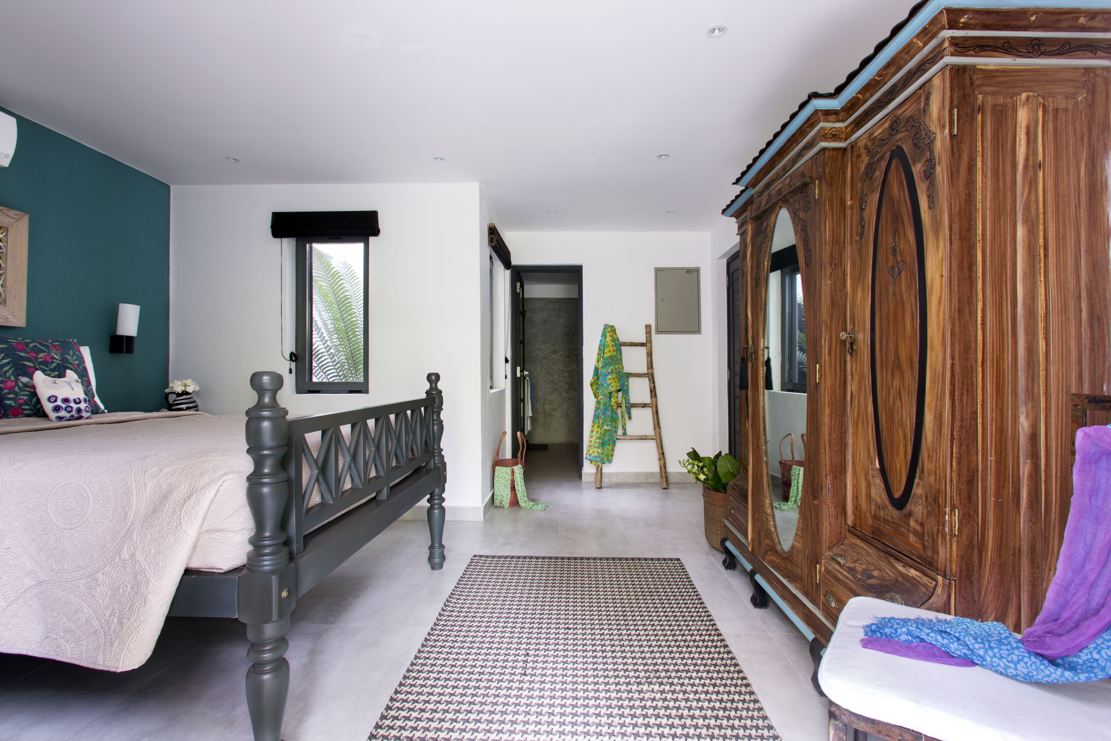 A bedroom with a bed, wardrobe, and a view of the hallway.