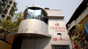 A building with a modern architectural design, featuring a prominent cylindrical structure and a sign that reads "Golden Residency." - Hotel Golden Residency (Mumbai)