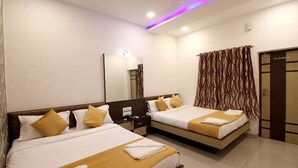 A hotel room with two beds, a large mirror, a wardrobe, and a curtain with a wavy pattern. - Hotel Golden Residency (Mumbai)