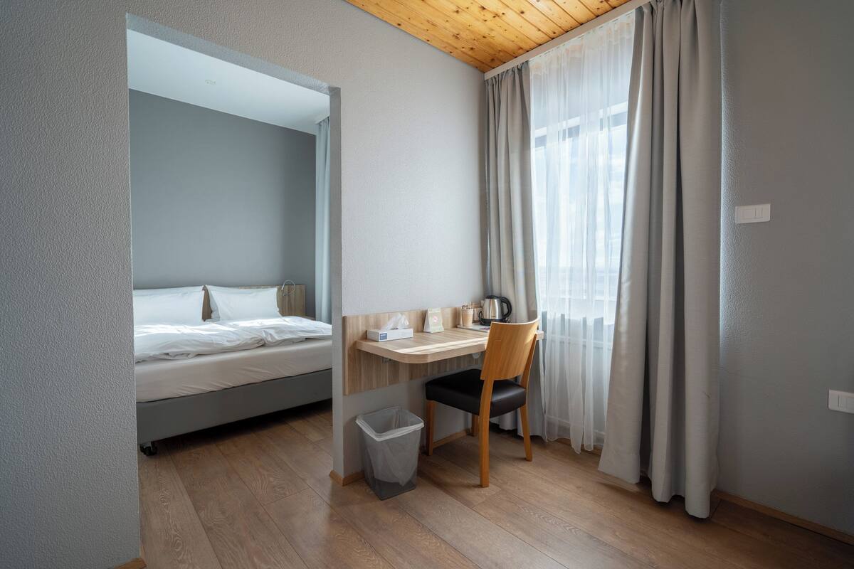 Une petite pièce comprenant un lit, un bureau et une chaise.