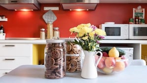 Una encimera de cocina con frascos de galletas y un jarrón de flores.