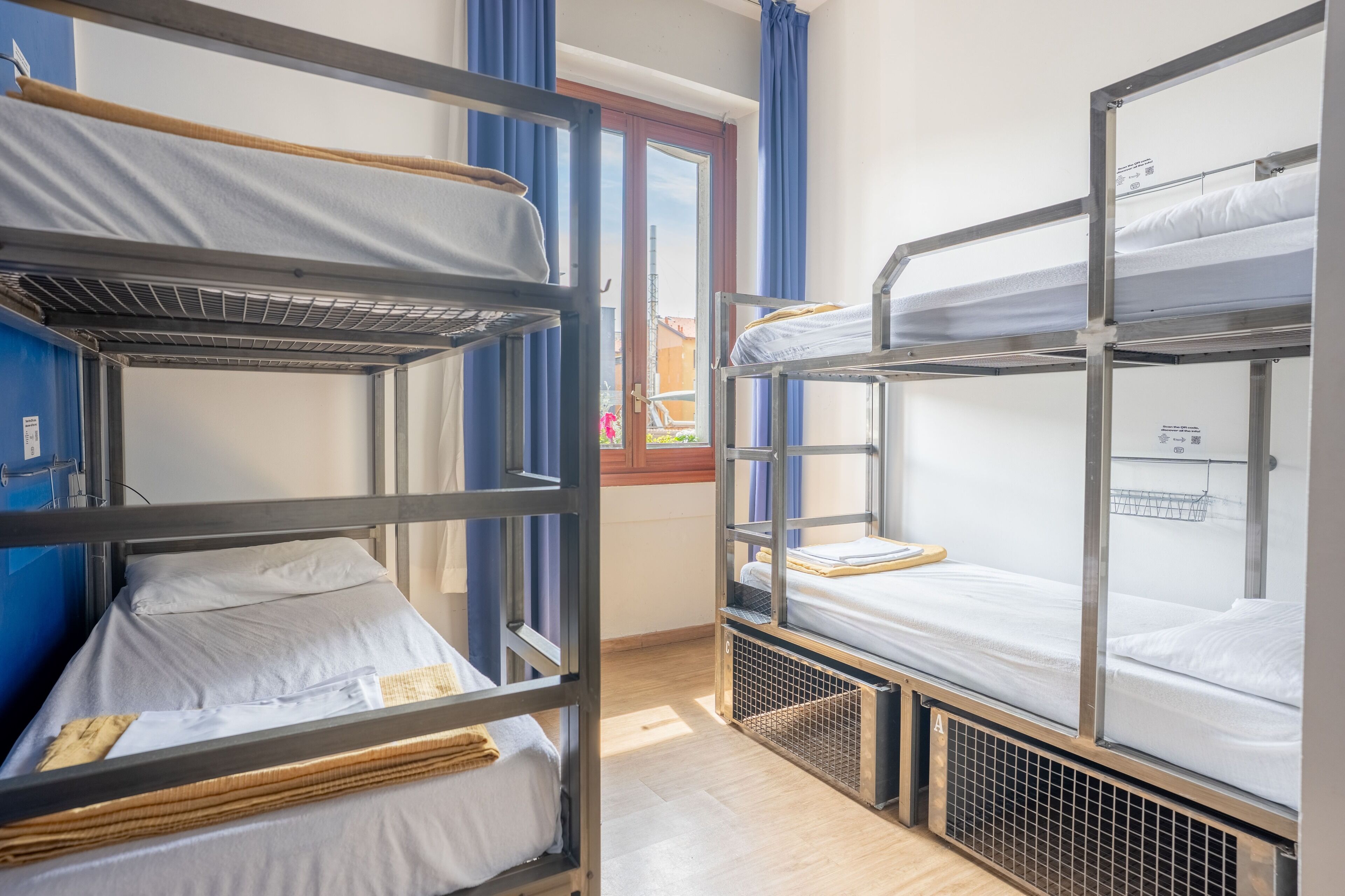Une chambre avec un lit superposé, une fenêtre, des rideaux et une porte.