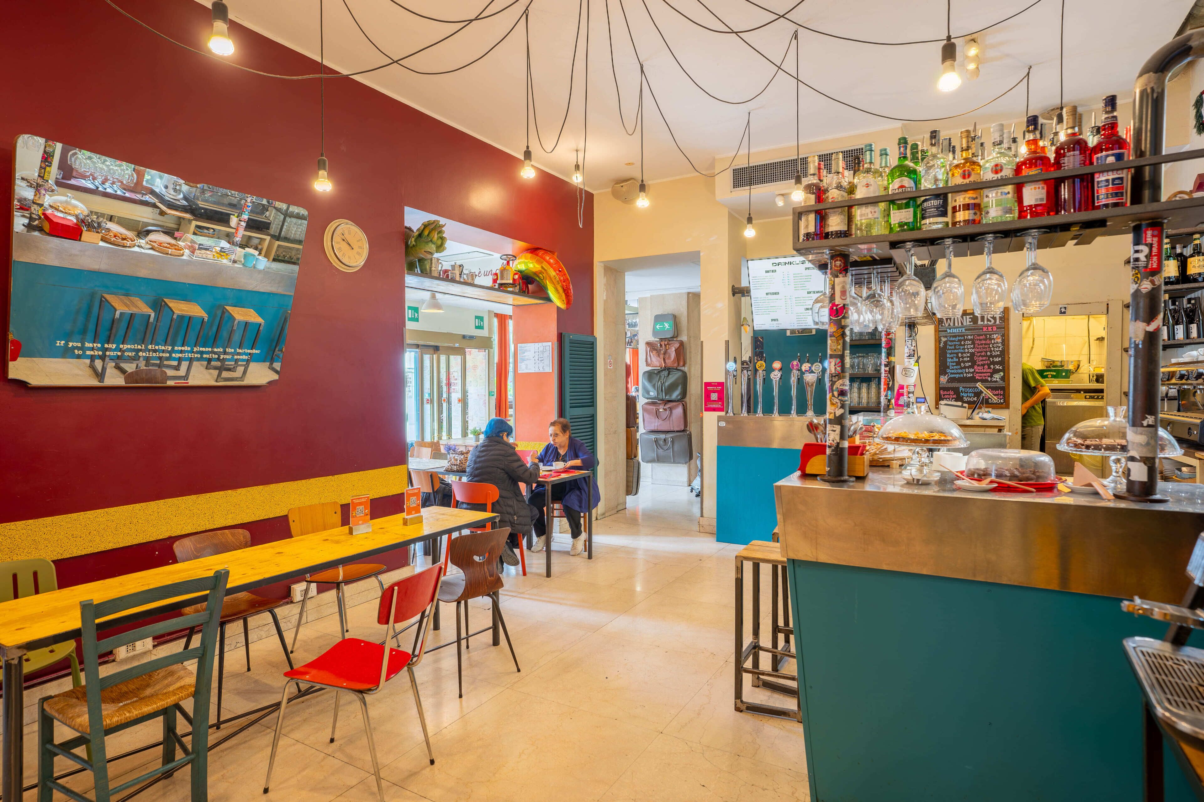 Interior de restaurante con barra, asientos y un tablero de menú.