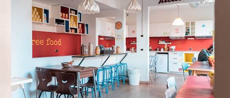 Una cocina moderna con armarios blancos, una pared de acento roja y un letrero que dice "free food".
