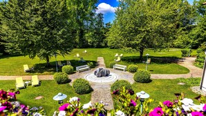 A garden with a circular seating area, a pathway, and various plants. - Hotel Sonnengarten (Bad Woerishofen)