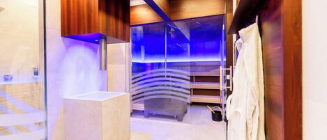 A modern bathroom with a glass shower enclosure, wooden accents, and a towel rack.
