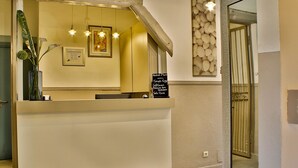 A reception desk with a wooden counter, framed artwork, and a chalkboard menu.