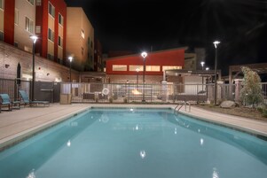 Una piscina al aire libre de temporada, sombrillas