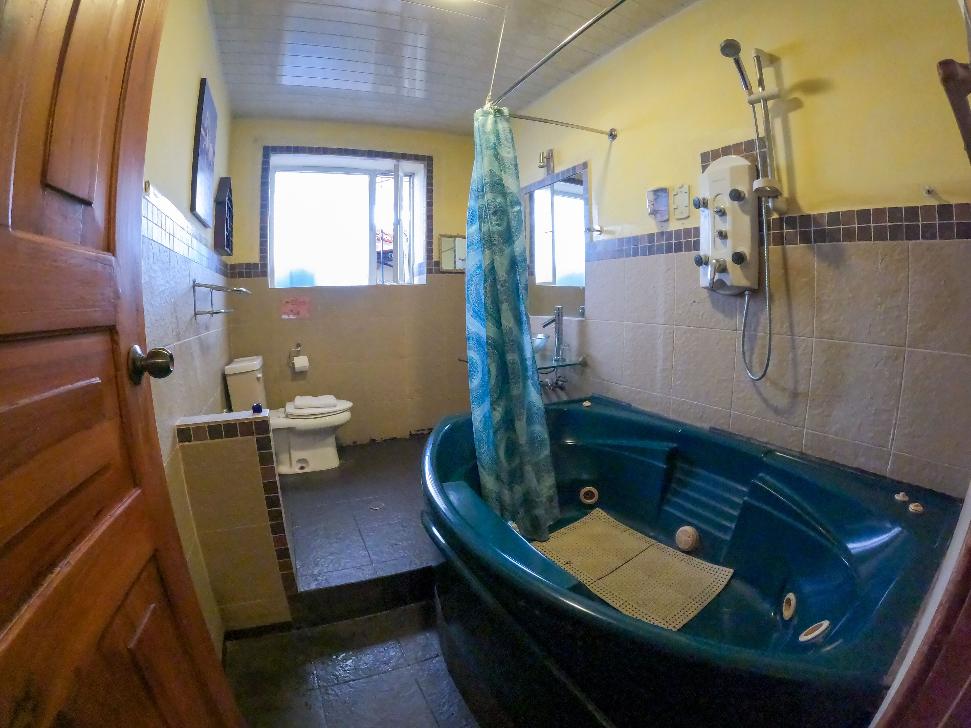 Ein Badezimmer mit Toilette, Waschbecken und einer Badewanne mit Duschbrause.