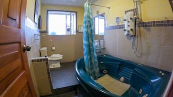 A bathroom with a toilet, sink, and a bathtub with a showerhead.
