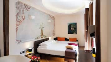 Una camera d'albergo con un letto, una scrivania, una TV e un grande quadro appeso al muro.
