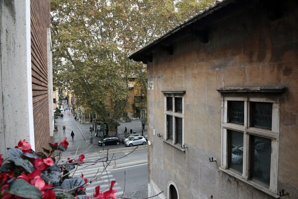 A street view with a building featuring a large window and a visible door. - Residenza delle Arti (Rome)
