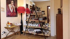 Ein Zimmer mit einem Holztisch, auf dem Obst und eine Schüssel Eier, eine rote Lampe sowie ein Küchenutensilienregal zu sehen sind.