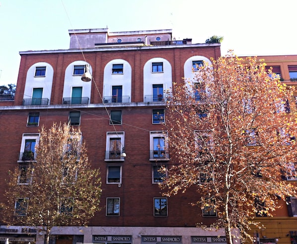 A multi-story building with a brick facade, multiple windows, and balconies. - Residenza delle Arti (Rome)
