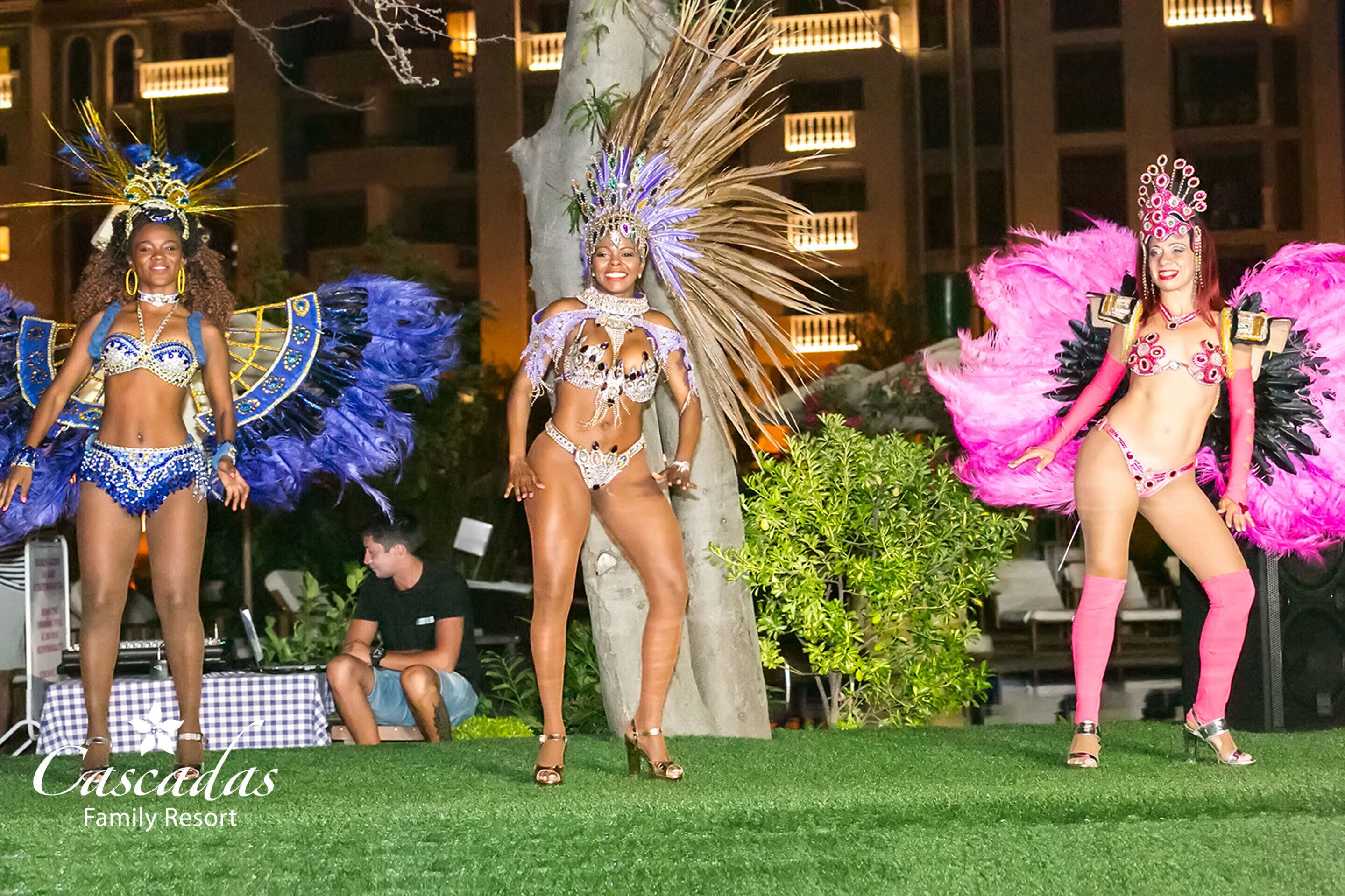 Un grupo de artistas con elaborados trajes en el Resort Familiar Cascadas.