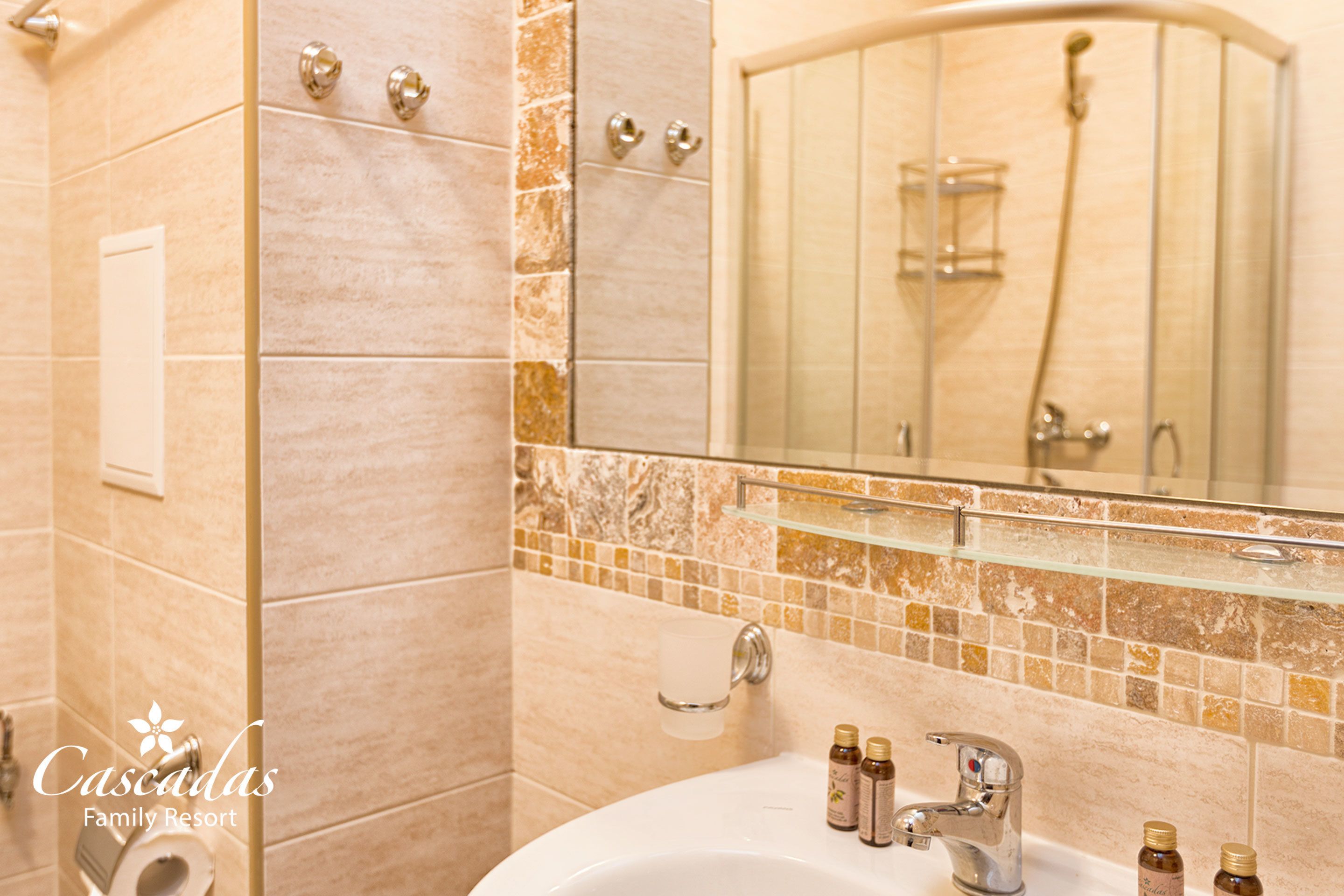 A bathroom with a sink, mirror, and shower.