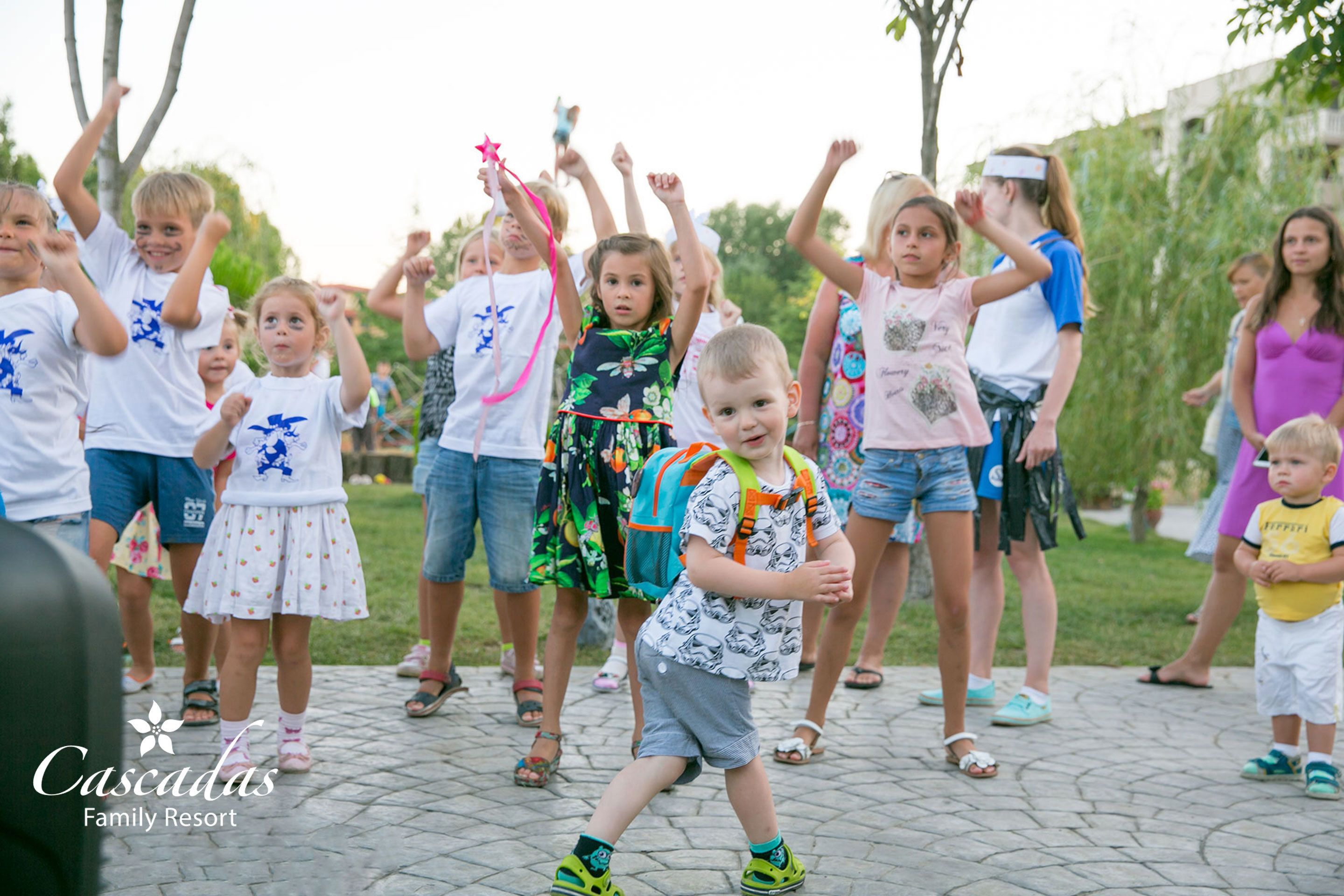 Een groep kinderen en volwassenen buitenshuis, mogelijk tijdens een familie evenement of bijeenkomst.