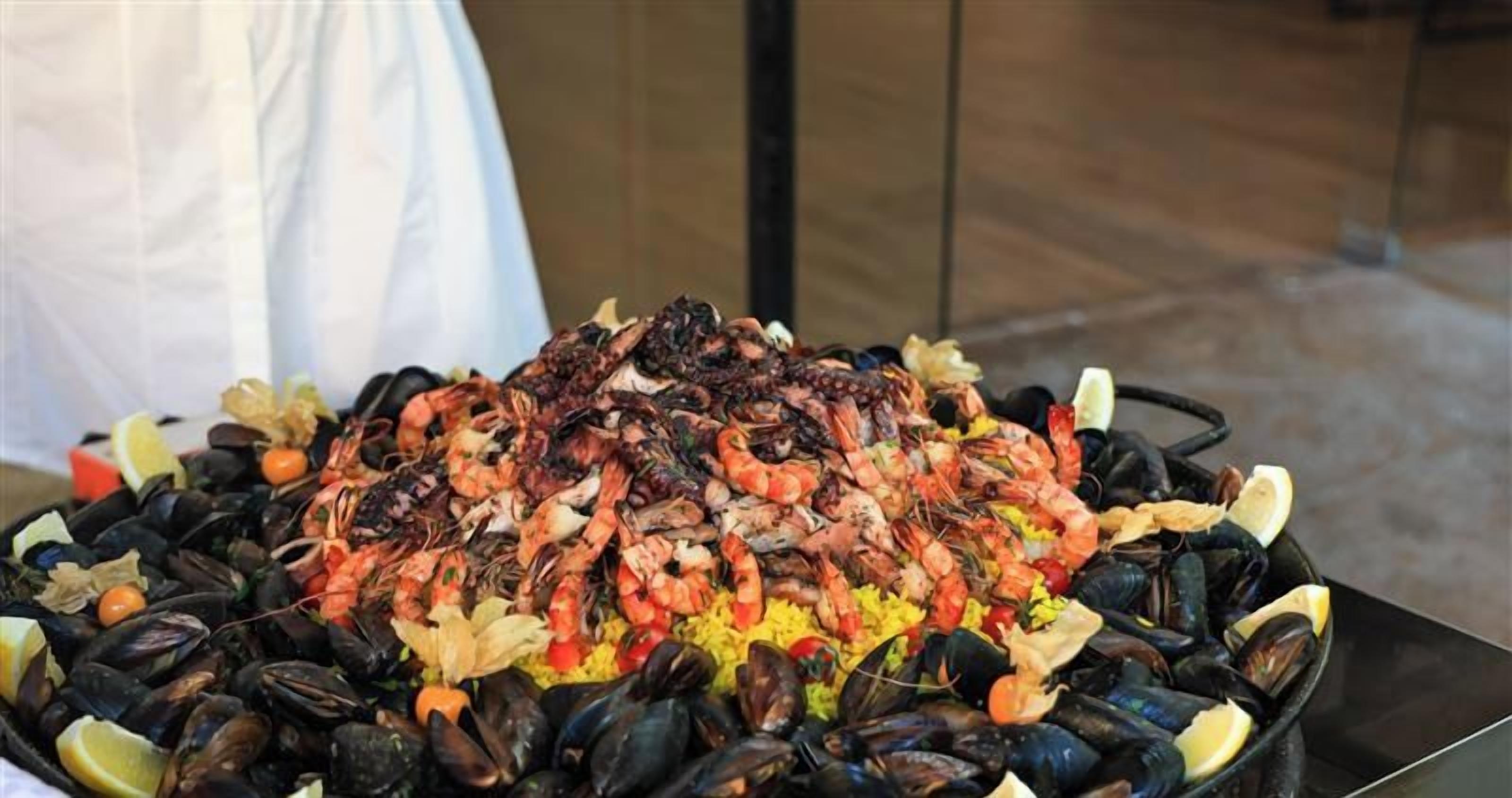 A seafood platter with shrimp, mussels, and rice, garnished with lemon slices.