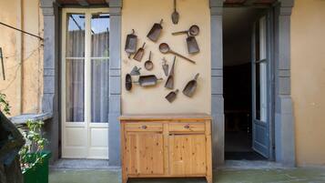 Un armadio in legno con cassetti davanti a un muro su cui sono appesi diversi attrezzi metallici.