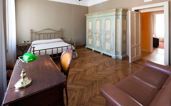 A bedroom with a bed, a desk with a lamp, a leather chair, a wardrobe, and a sofa. - Bed & Breakfast Ekoliving (Milan)