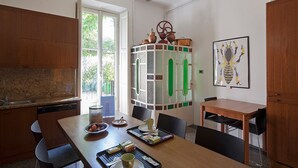 Una cocina con encimera de granito, lavavajillas, una mesa de comedor con sillas y un mueble con azulejos decorativos.
