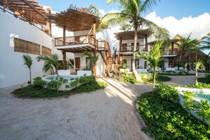 A resort with multiple buildings, outdoor pools, and a sandy pathway.