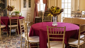 A formal dining room with a chandelier, round tables, and chairs. - The Hollinger House (Lancaster)