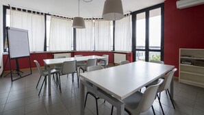 A conference room with a white table, chairs, a whiteboard, and large windows with curtains. - La Cordata Accommodation - Zumbini 6 (Milan)