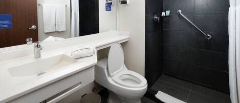 Un baño moderno con lavamanos, inodoro y ducha blancos.