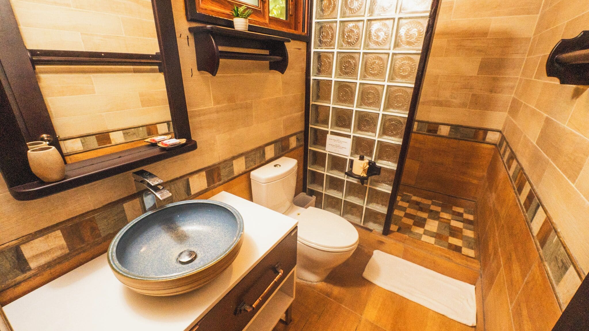 Et badeværelse med stor vask, toilet og bruseområde.